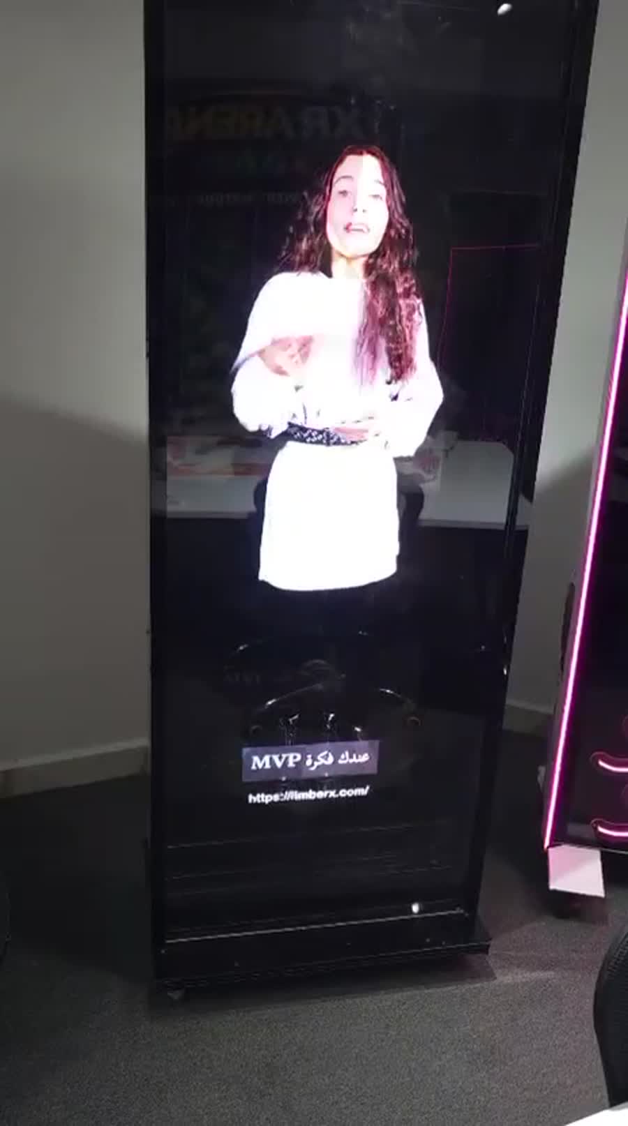 A presenter appearing inside a physical hologram display at an event